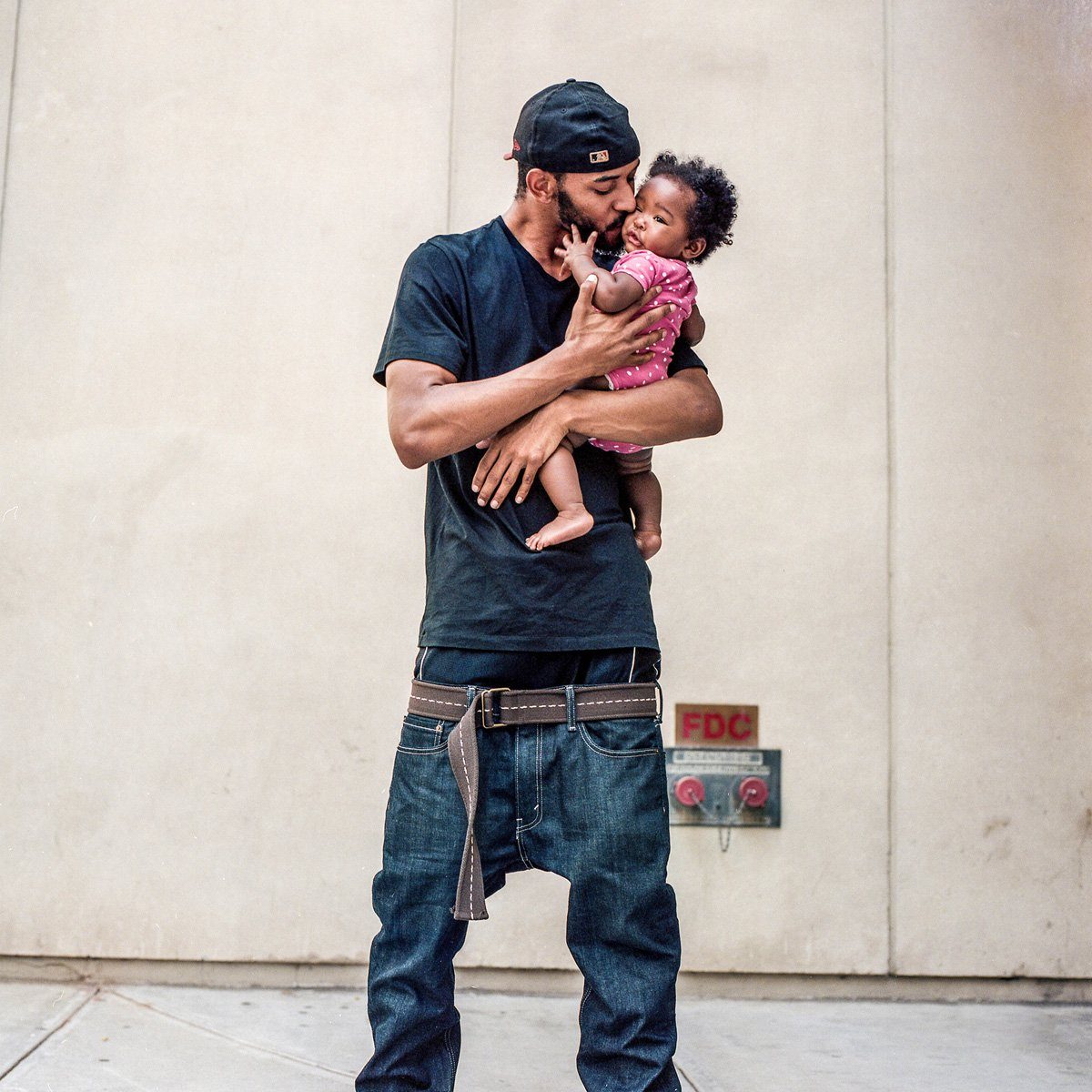 A father and his child photographed together in available light.